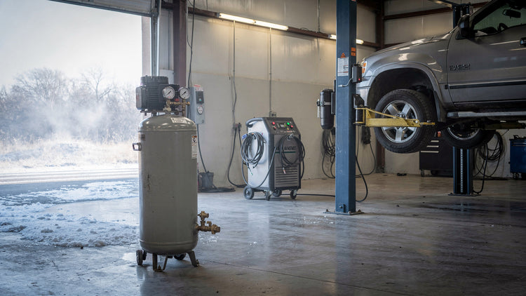 Air compressor, A/C service machine and two-post lift in a Texas repair shop on a frosty winter morning