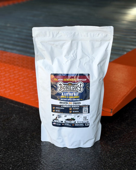 BoneDry ALL 3 lb resealable spill absorbent in a homeowner garage on an automotive lift — sold as a case of 6