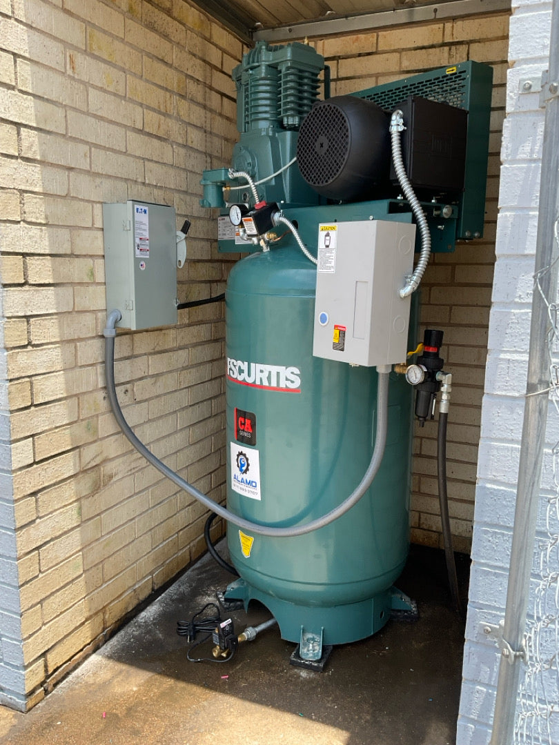 FS-Curtis tank-mounted air compressor installed by Alamo Equipment in a dedicated commercial compressor enclosure